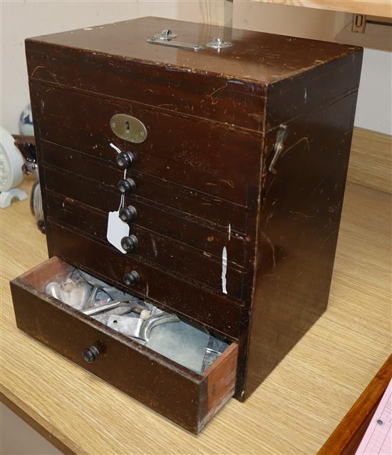 A mahogany six draw dentists cabinet with tools
